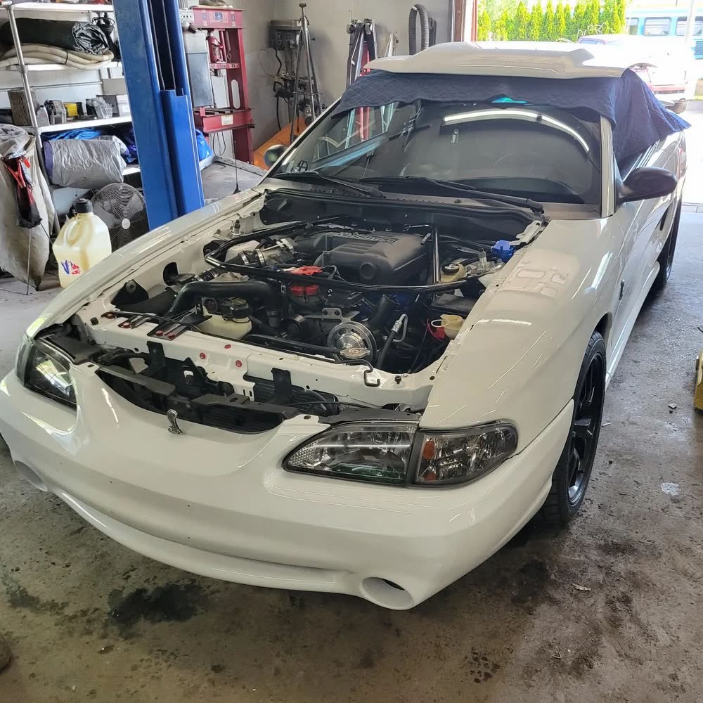 Mustang in the shop with hood panels removed for engine service