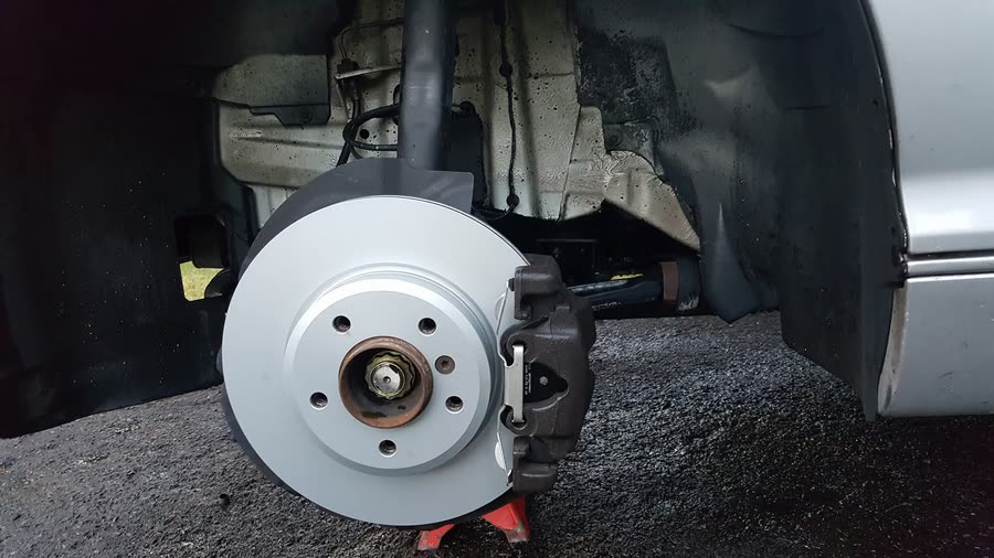 Brand new brake rotor and caliper installed on a vehicle