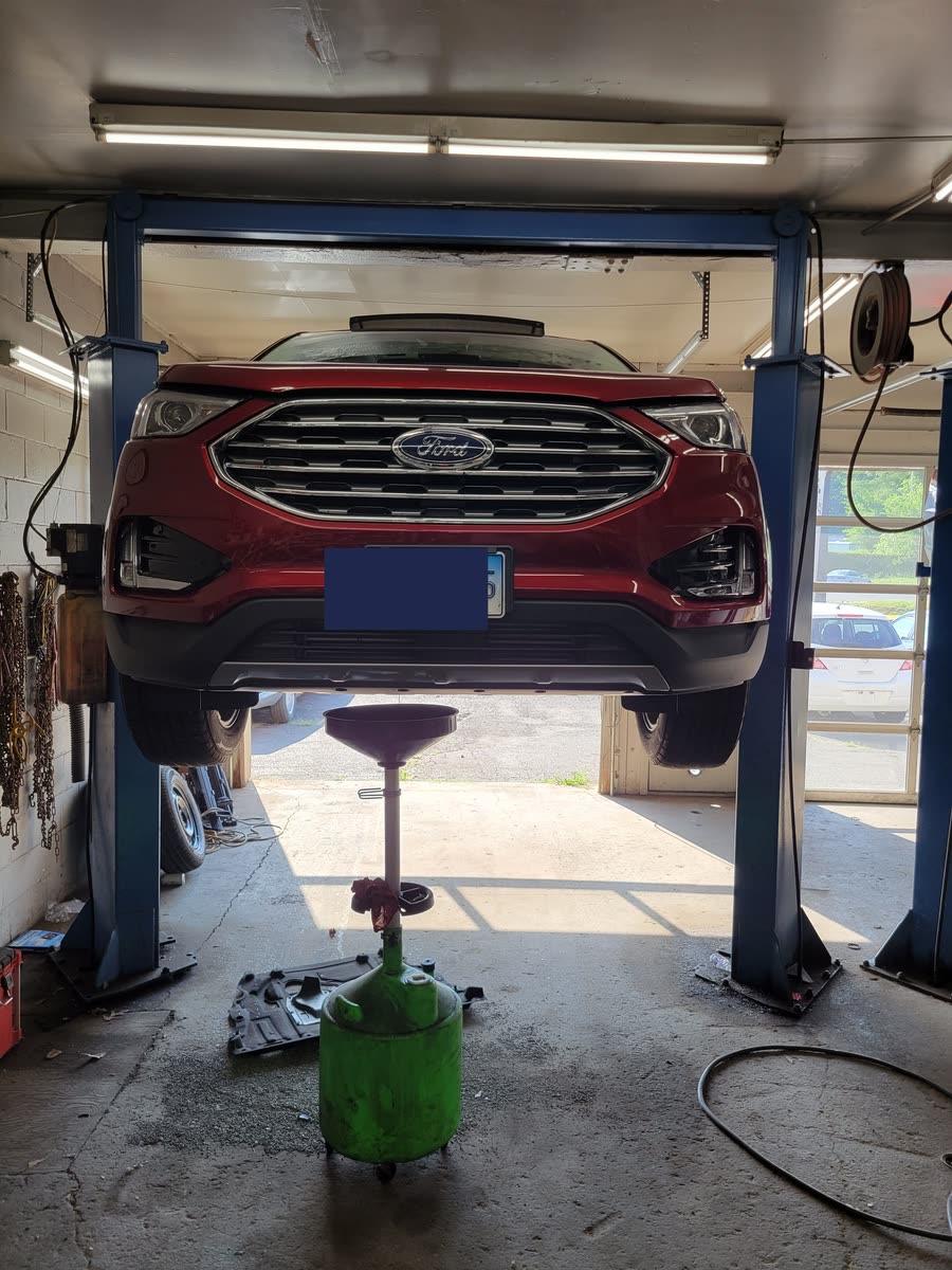SUV raised on a lift for an oil change at Just Right Automotive in Bristol, CT