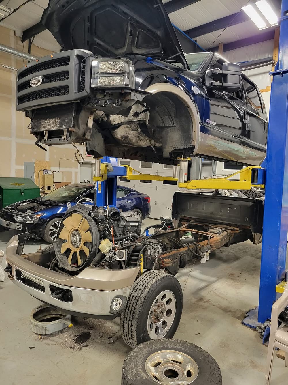 Pickup truck cab lifted off its frame inside the shop for repair